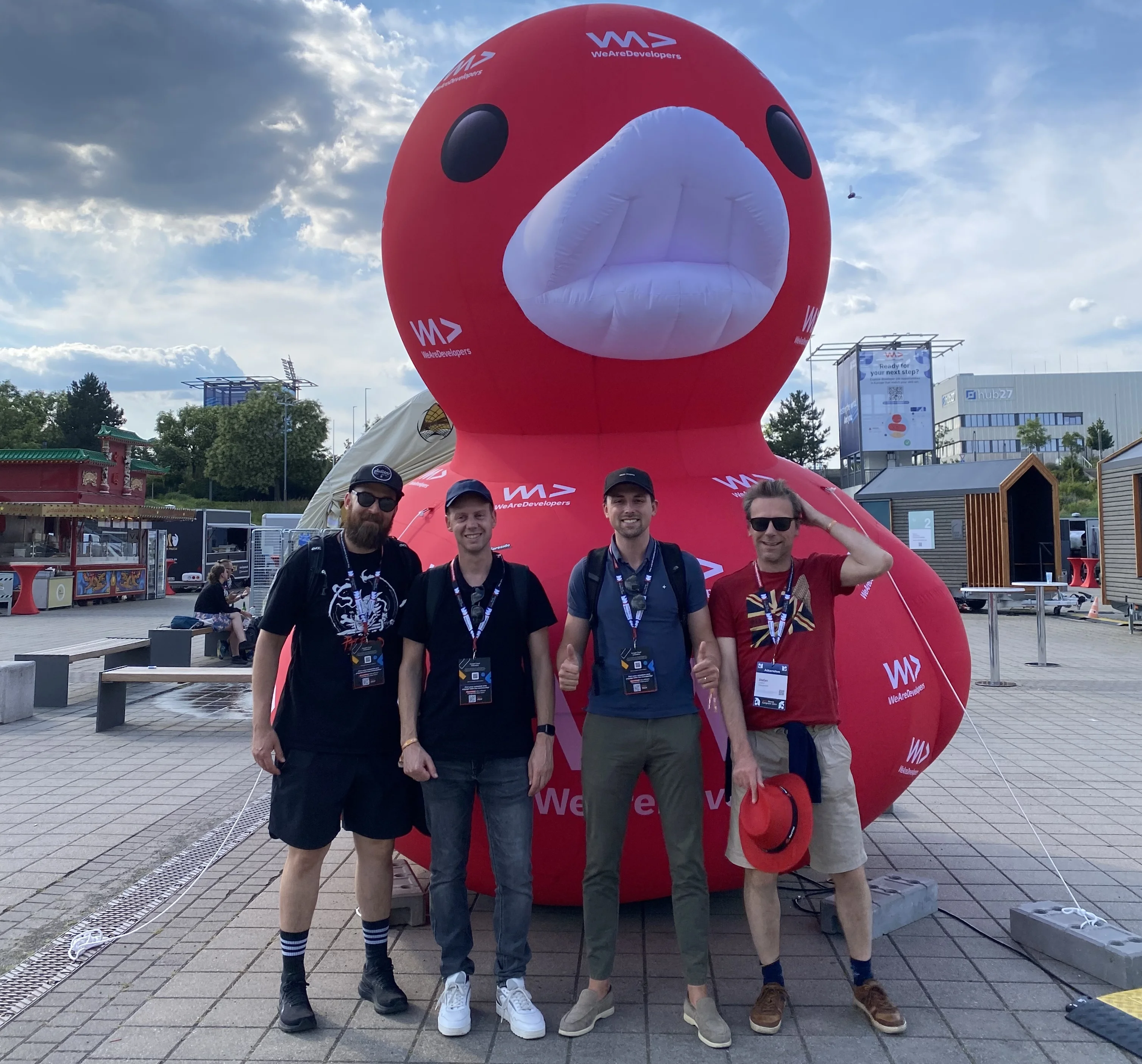 Posing with a group of four colleagues in front of the WeAreDevelopers mascot, a large rubber duck.
